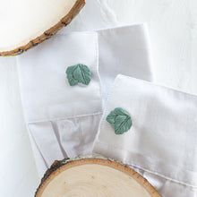 Load image into Gallery viewer, Cufflinks with a leaf pattern are styled on the cuffs of a white shirt, against a white background.