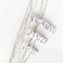 Load image into Gallery viewer, Group of white, black, and beige polymer clay barrettes designed to look like birch bark.