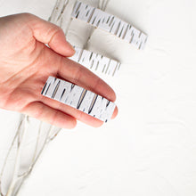 Load image into Gallery viewer, Hand holds a small birch bark polymer clay barrette.