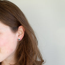 Load image into Gallery viewer, Model wears tiny green and white mountain triangle polymer clay studs.