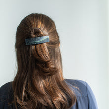Load image into Gallery viewer, A model with brown hair wears a medium dark blue polymer clay barrette that has a northern lights design.
